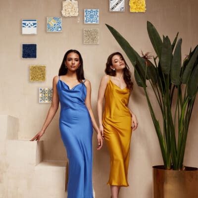 Two pretty beautiful woman brunette hair natural makeup wear fashion clothes sexy silk long dress midi style date party walk sandals interior studio stairs flowerpot summer journey romantic friends.