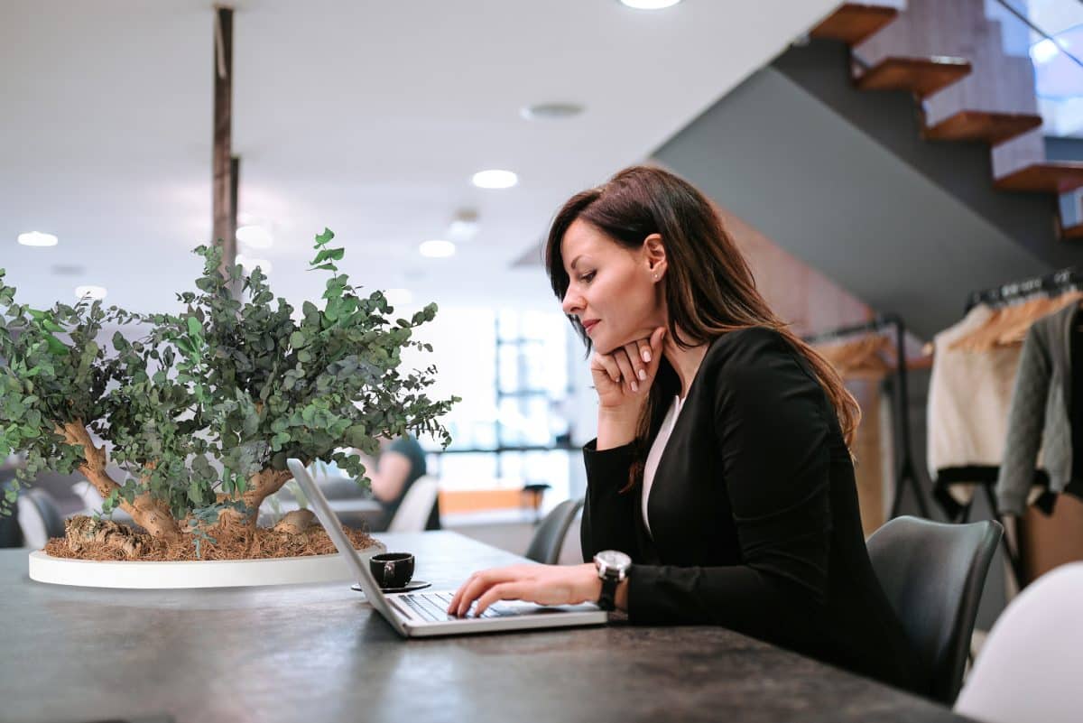 Young woman using laptop in open coworking office