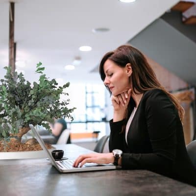 Young woman using laptop in open coworking office