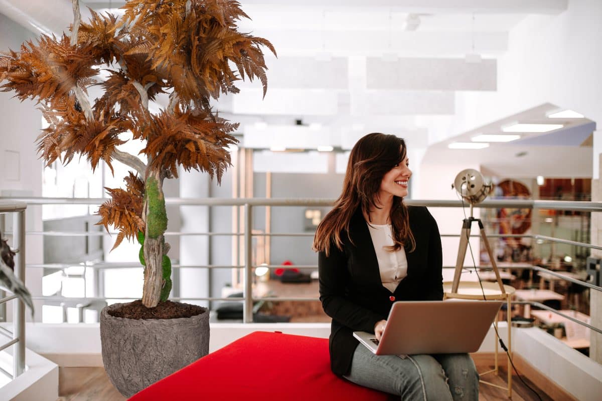 Successful manager sitting with laptop looking away