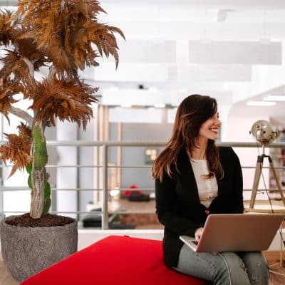 Successful manager sitting with laptop looking away